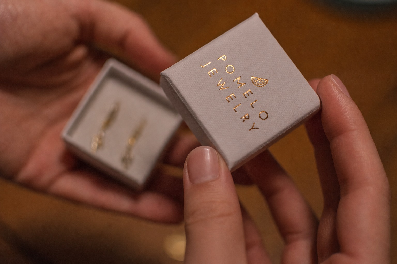 Pomelo Jewelry gift box held in carefully manicured hands